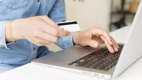 ผู้หญิงถือบัตรเครดิตกำลังช้อปออนไลน์